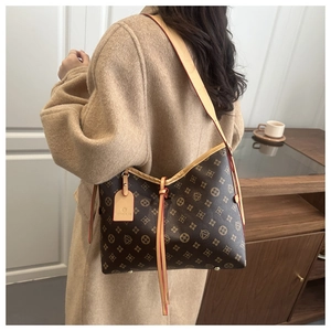 Detail of vintage monogram brown tote bag with leather strap and decorative logo hangtag