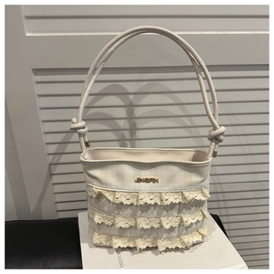 Detail of cream shoulder bag featuring elegant lace layers and textured checkered pattern