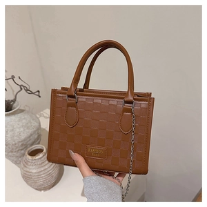 Détail du sac à main marron avec motif damier gaufré et fine bandoulière en chaîne
