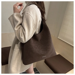 Dettaglio borsa shopper marrone minimalista con scritta fashion e trama pelle opaca