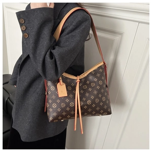Detail of printed tote bag featuring leather straps with red edge paint and metal studs