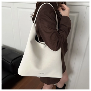 Dettaglio di una grande borsa tote bianco crema con testo FASHION e morbida pelle opaca