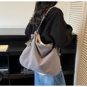 Détail du grand sac cabas en velours côtelé gris avec bandoulières rayées et nœuds décoratifs