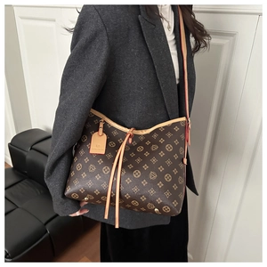 Detail of vintage printed tote bag with brown monogram pattern and leather straps