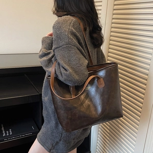 Minimalist large brown leather tote bag for women shown in a cozy autumn lifestyle setting