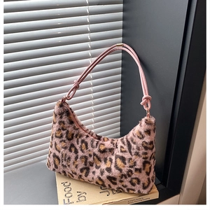Detail of pink leopard faux fur handbag with knot strap and gold metal hardware