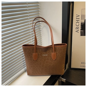 Close-up of leopard print tote bag with thin brown straps and FASHION lettering