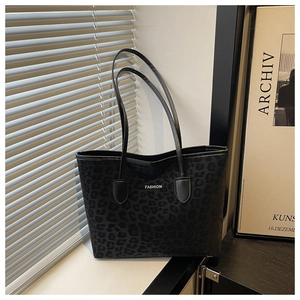 Detail of shadow leopard print tote bag with white FASHION text and long handles