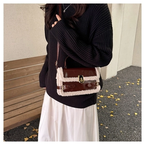 Detail of brown leather crossbody bag with plush trim and gold metal twist lock closure
