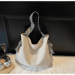 Détail du sac cabas en velours côtelé crème montrant la texture et les anses tressées