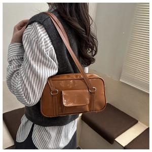Detail of vintage brown leather bag featuring white contrast stitching and pocket