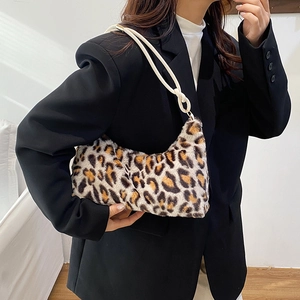 Minimalist leopard print faux fur shoulder bag worn by model in a stylish indoor setting