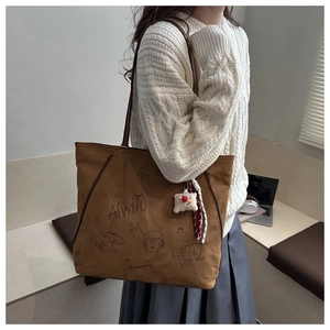 Braune Shopper-Tasche aus Wildleder mit Doodle-Kunst und Plüsch-Anhänger im Alltag