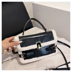 Detail of vintage crossbody bag with black PU leather, white faux fur trim and gold clasp