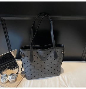 Detail showing grey tote bag with black polka dots, bow embroidery, and leather straps