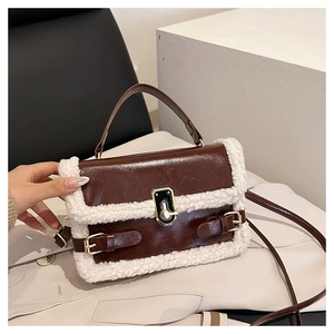 Detailed close-up of brown faux leather shoulder bag with white faux shearling trim accents
