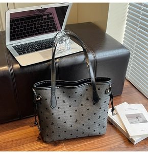Detailed view of grey canvas tote bag with black polka dots and leather trim details