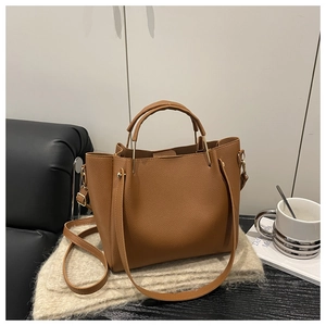Dettaglio della borsa tote color caramello con trama a grana e finiture in metallo dorato