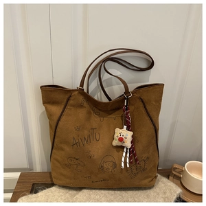 Detailansicht braune Shopper-Tasche mit Comic-Print und Plüsch-Clown-Anhänger