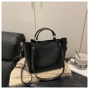 Dettaglio borsa tote in pelle nera a grana con hardware dorato e tracolla regolabile