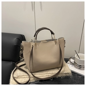 Dettaglio della borsa tote beige in pelle martellata con manici marroni e dettagli oro