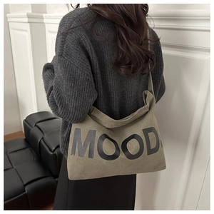 Borsa a tracolla in tela verde oliva con scritta MOOD su un maglione grigio a maglia