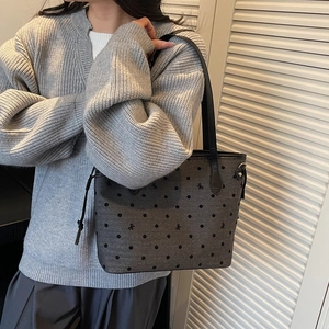 Minimalist grey polka dot tote bag with black bow patterns and drawstring side details