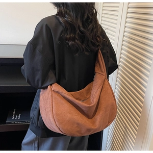 Brown textured hobo crossbody bag styled on shoulder showing oversized soft slouchy fit