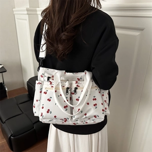 Minimalist white tote bag with red cherry print, featuring multiple functional pockets