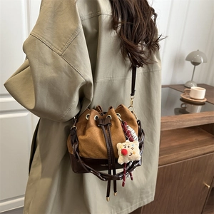 Retro patchwork suede bucket bag with braided handle and cute bear pendant charm