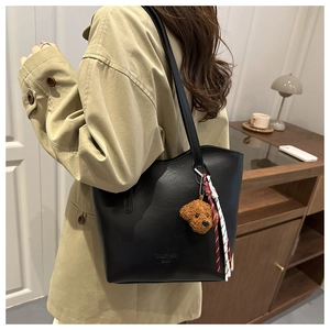 Détail du sac cabas noir en similicuir avec charme d'ours en peluche et cordon tressé