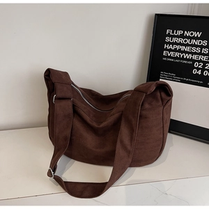 Detail of brown corduroy tote bag showing textured fabric and silver metal buckle