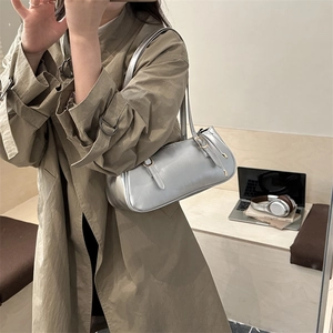 Sac bandoulière argenté pour femme porté par un mannequin dans un cadre décontracté