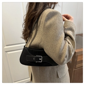 Detail of minimalist black matte leather underarm bag with silver square metal buckle
