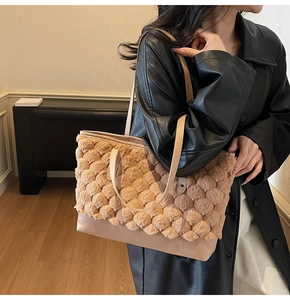 Détail d'un sac cabas en peluche marron chaud avec des lanières en cuir pour l'hiver
