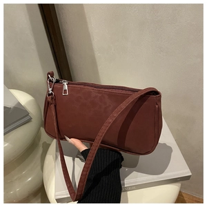 Detail einer burgunderfarbenen Baguette-Tasche mit silbernen Elementen und Textur