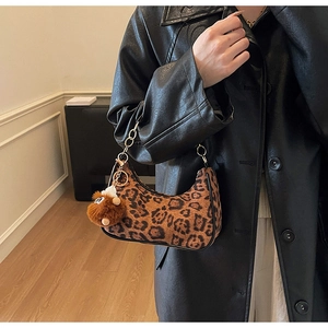 Dettaglio della borsa hobo leopardata con catena in metallo e ciondolo di peluche