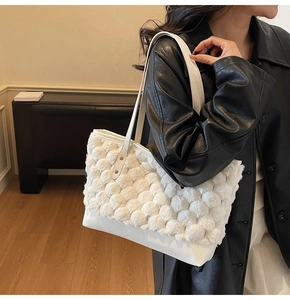Détail du sac cabas blanc en peluche tissée avec pompons et base en cuir lisse