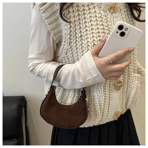 Close-up of a dark brown suede hobo bag with sleek gold hardware and minimalist design