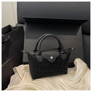 Close-up of black leopard embossed nylon tote bag with leather handle and silver hardware