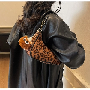 Borsa sottobraccio leopardata con catena dorata e ciondolo a orsetto su modella