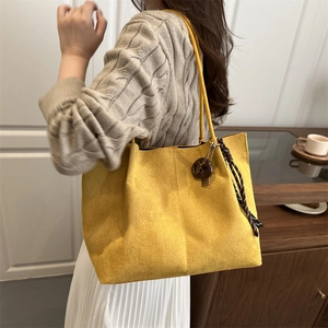 Large yellow faux suede tote bag with decorative pendant for casual daily shoulder wear