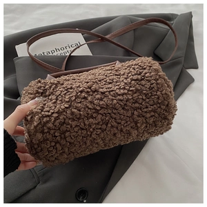 Dettaglio borsa a cilindro in peluche marrone con manico in pelle e tracolla