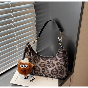 Dettaglio borsa leopardata con tracolla a catena dorata e ciondolo in peluche a forma
