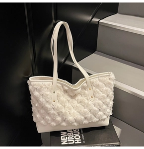 Détail du sac cabas en peluche blanche avec texture sphérique et base en similicuir