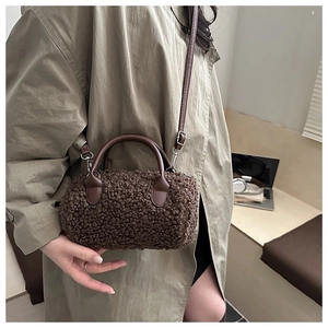 Dettaglio di borsa a cilindro marrone in peluche con texture morbida e tracolla