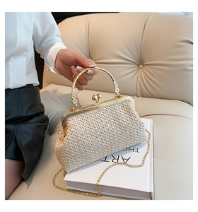 Detail of cream woven shell bag featuring gold metal ring handle and ball clasp closure