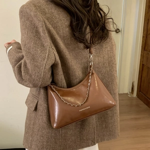 Brown glossy croissant shoulder bag with metal chain strap and white fashion lettering