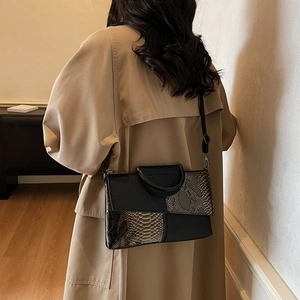 Chic black and snakeskin pattern crossbody bag paired with an elegant beige trench coat