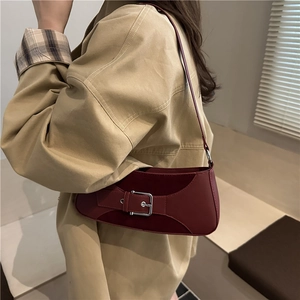 Minimalist burgundy leather shoulder bag with silver buckle and sleek underarm design